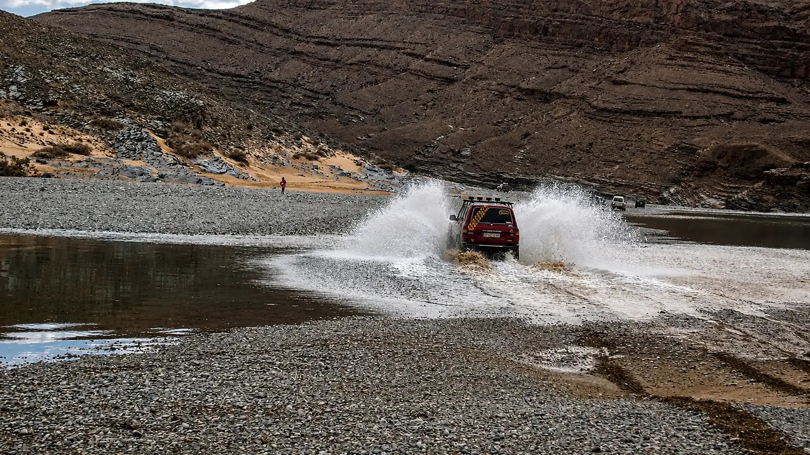 Todoterreno cruzando un río a gran velocidad en una ruta por Marruecos